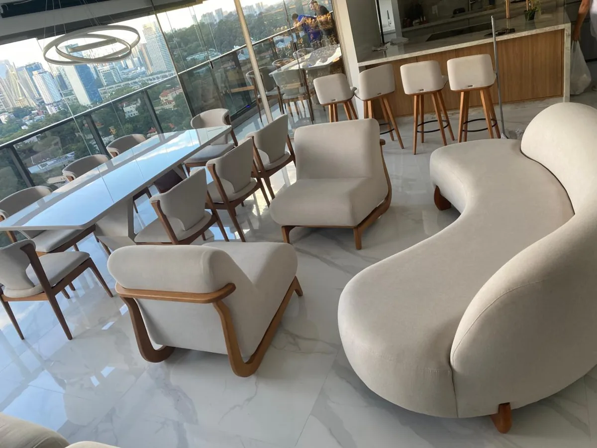 Poltronas brancas e sofá curvo em lounge comercial