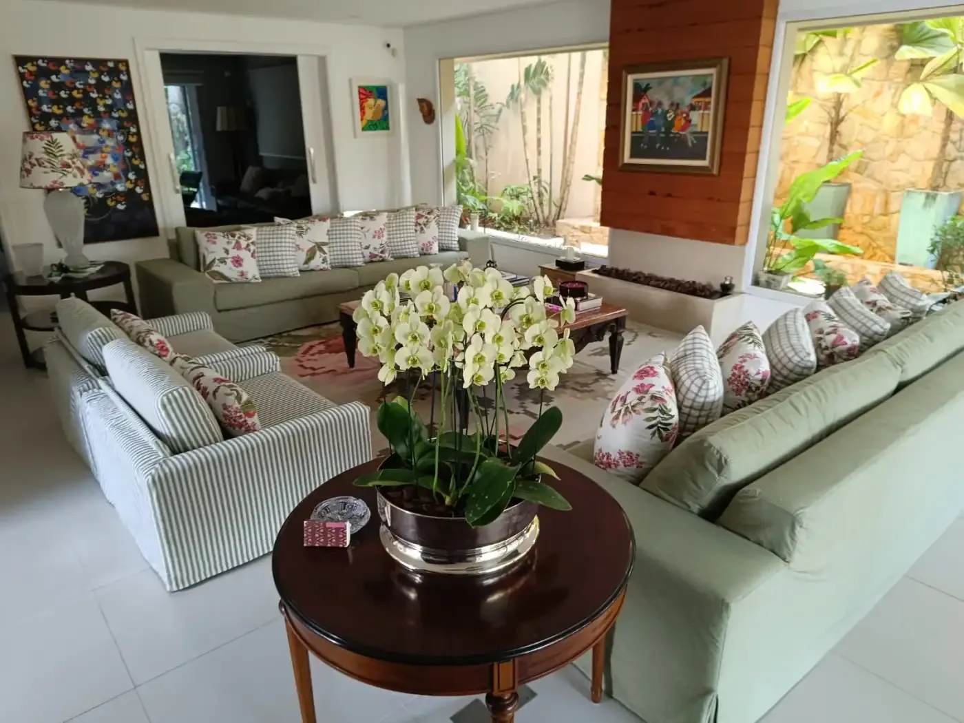 Sala com sofás claros e arranjo de flores