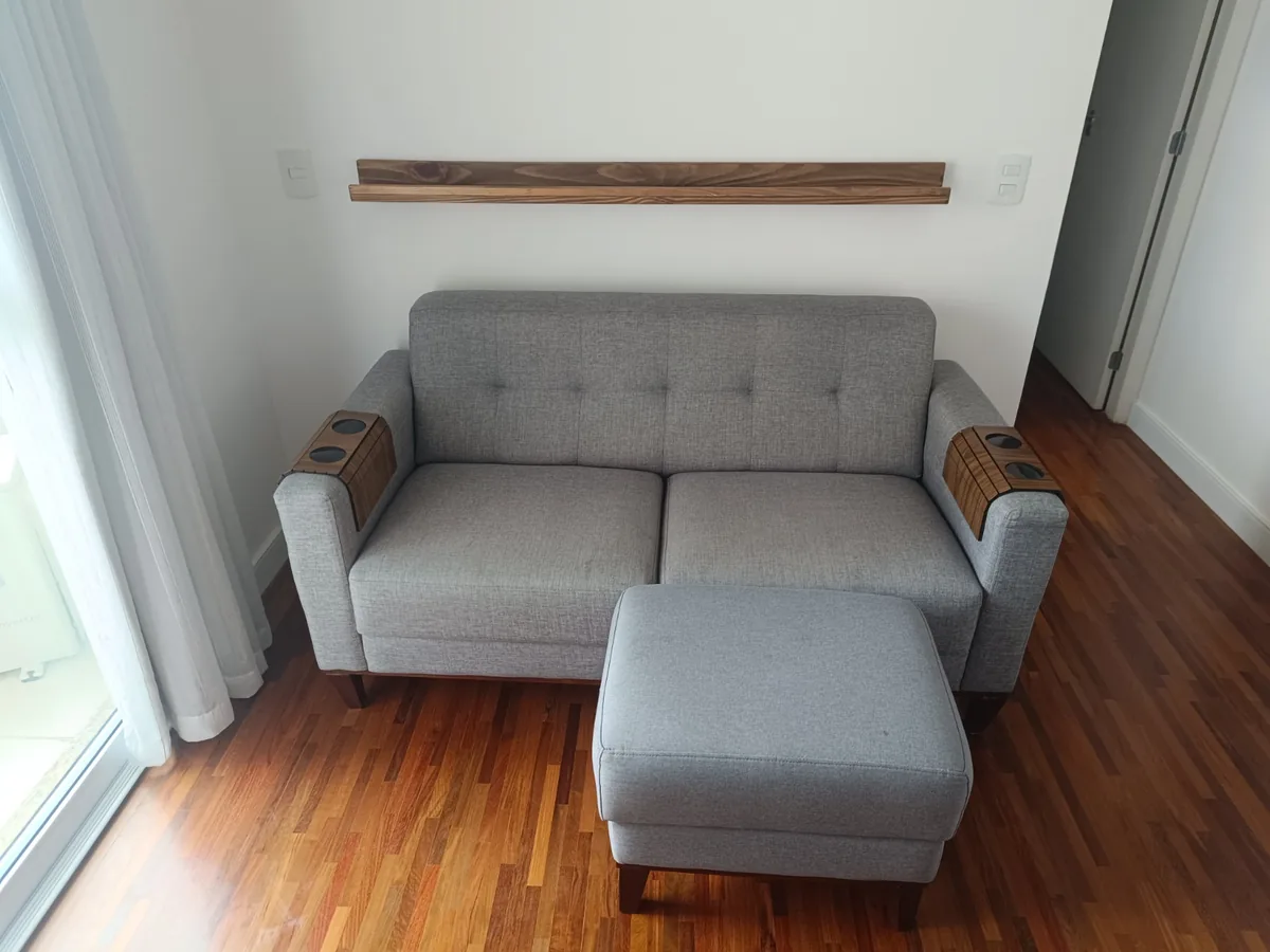 Sofá cinza de dois lugares com puff