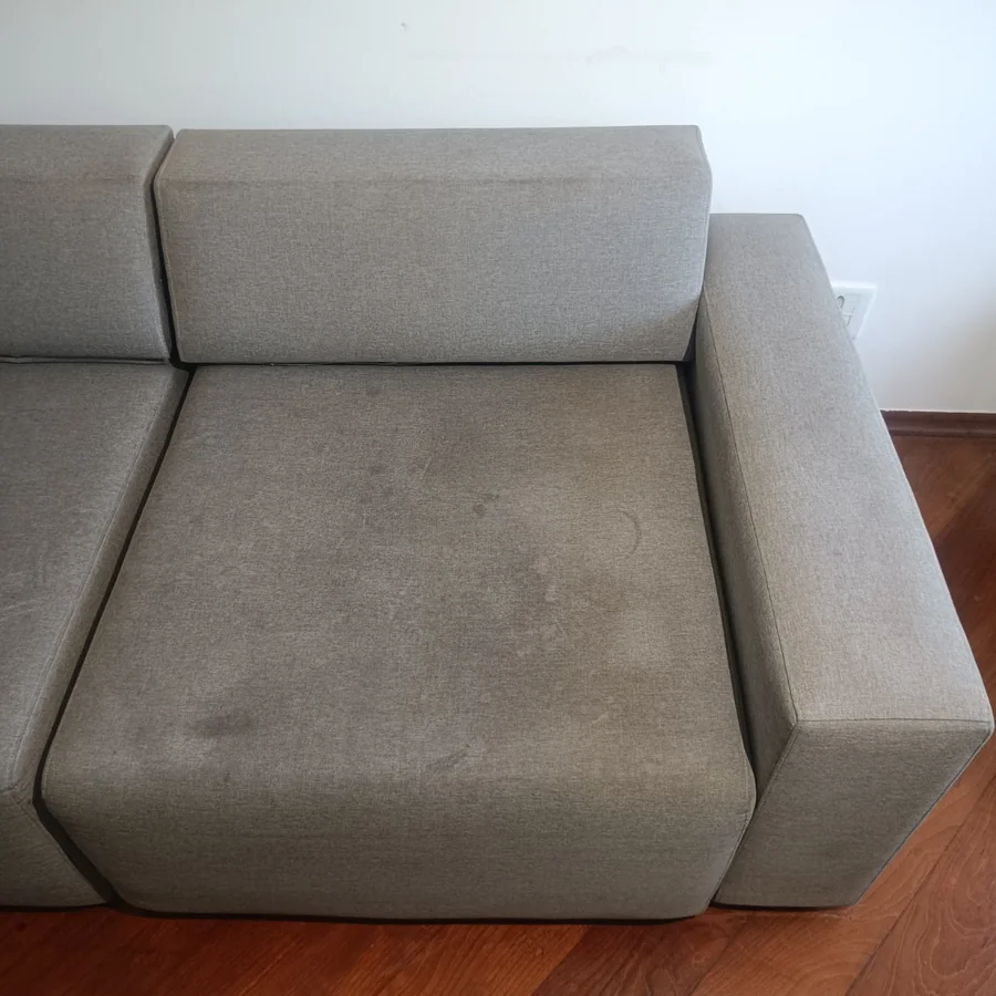 Sofá cinza com chaise antes da higienização, encardido e manchado